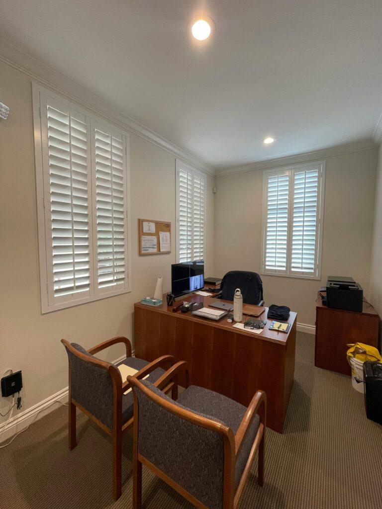pexels-photo-30546668-30546668 A well-lit modern office with desk, chairs, and shutters creating a professional atmosphere.